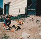 Picture of a kid playing with toys on soil.